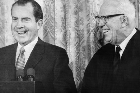 President Richard Nixon smiles alongside Chief Justice of the United States Earl Warren, even though the two waged political war against each other for decades