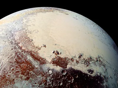 A color composite image highlighting pluto's brilliant diversity of color and texture. The western lobe of the heart—an area rich with nitrogen, carbon monoxide and methane ice—is brightly displayed in the right of the image.  