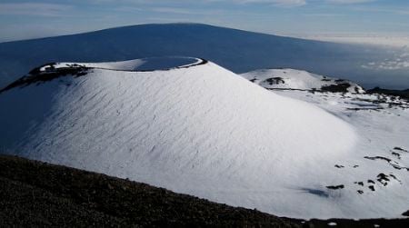 Mauna Loa (as seen from nearby Mauna Kea) is tall enough to have snow, at least when the volcano isn't erupting