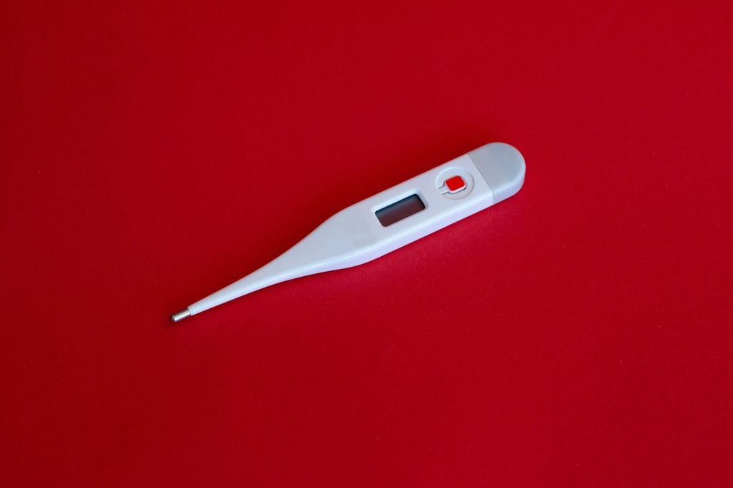 Thermometer on red background