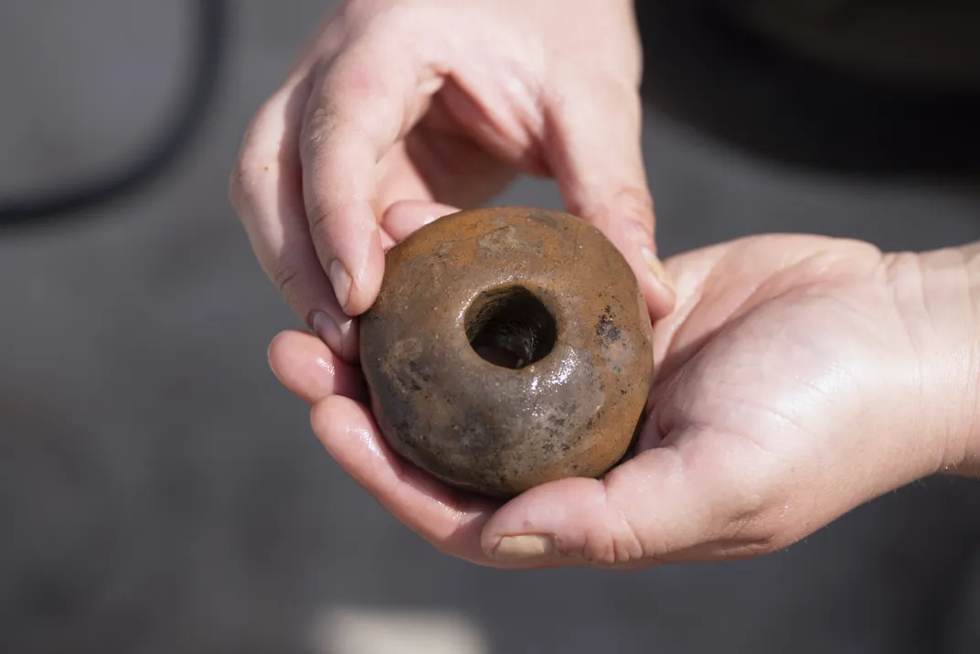 A person holding a round object with a hole in the middle