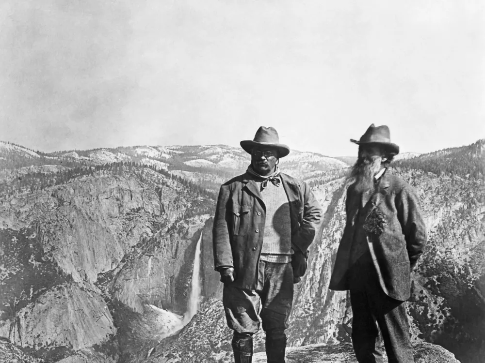 Theodore Roosevelt stands with naturalist John Muir on Glacier Point, above Yosemite Valley, California, USA.
