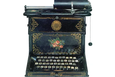 Sholes and Glidden gussied up an early model with floral ornaments, in imitation of sewing machines.