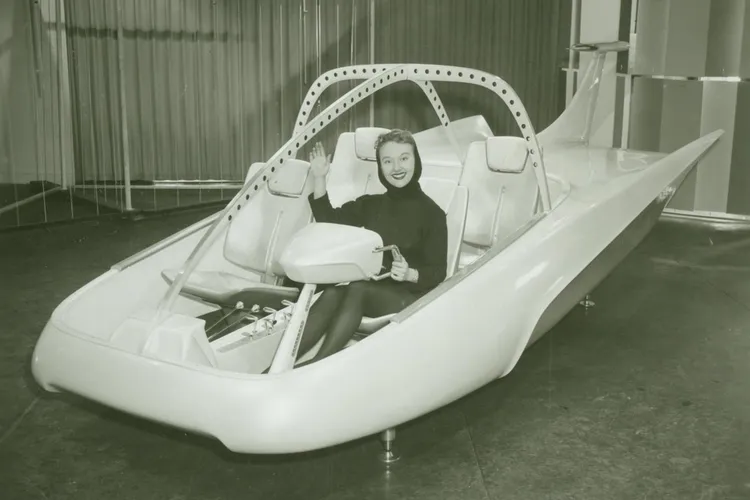 A woman poses in a full-scale model of the Studebaker-Packard Astral