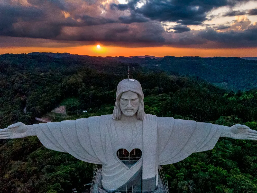 Image of the top half of "Christ the Protector" with the sun setting in the background