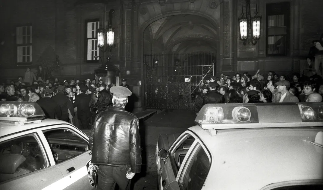 Crowd gathers outside site of Lennon assassination