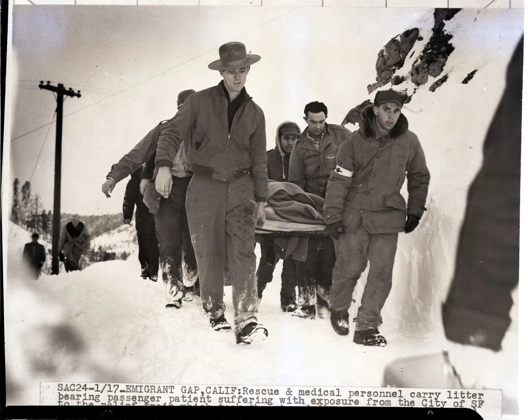 Rescuers transport a passenger to safety on a stretcher.