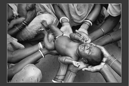GRAND PRIZE WINNER
A tribal birth in India
Purulia, India &bull; Photographed August 2007
Six days after Betka Tudu's birth, female relatives and neighbors in the West Bengal village of Purulia gathered to bless him and "to protect him from harm's way," says Dey. Born into the Santhal tribe, Betka "unknowingly drew his distant kin closer than ever." &mdash; Abigail Tucker

