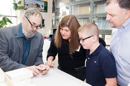 Ten-year-old Noah Cordle visited the National Museum of Natural History on November 3 to donate a Clovis point he found in New Jersey. He and his parents (right) met with the museum's Dennis Stanford (left).