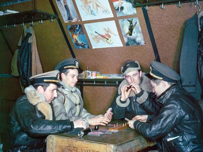 Some photos show intimate moments: At a remote base in the Aleutian Islands, U.S. Navy aircrew amuse themselves with cribbage—and posters of pin-up girls.