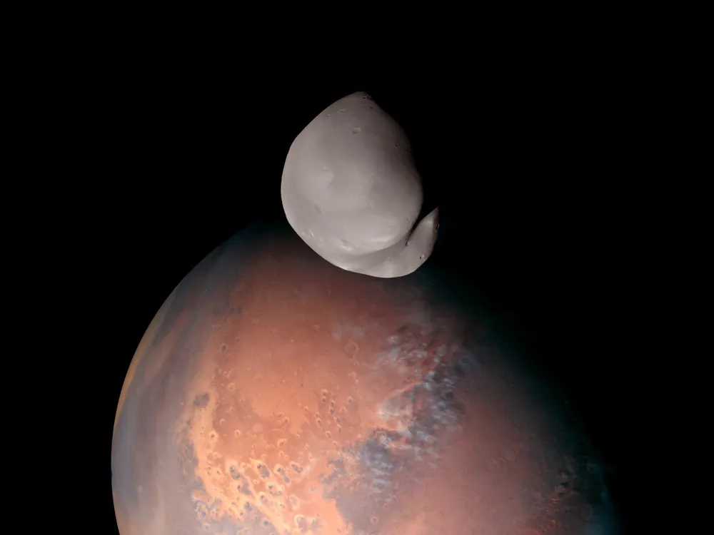 small grey moon in front of red planet