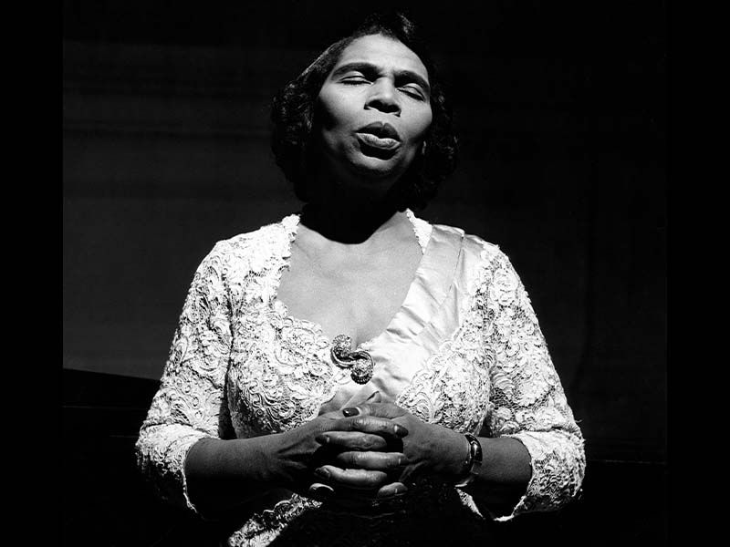 A women sings wearing a white dress