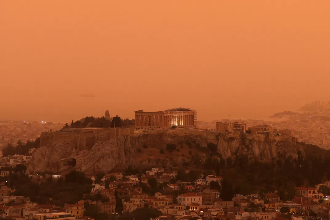 A wide-angled view of the city of Athens, turned orange from dust blown from the Sahara desert.