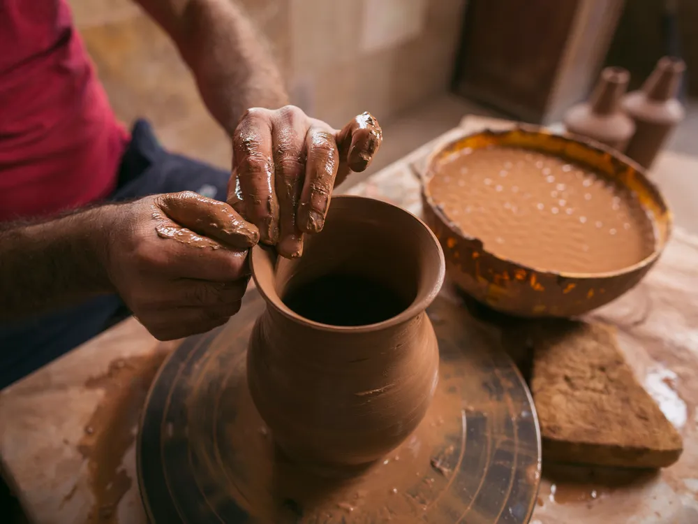 Potter at work at his pottery wheel 