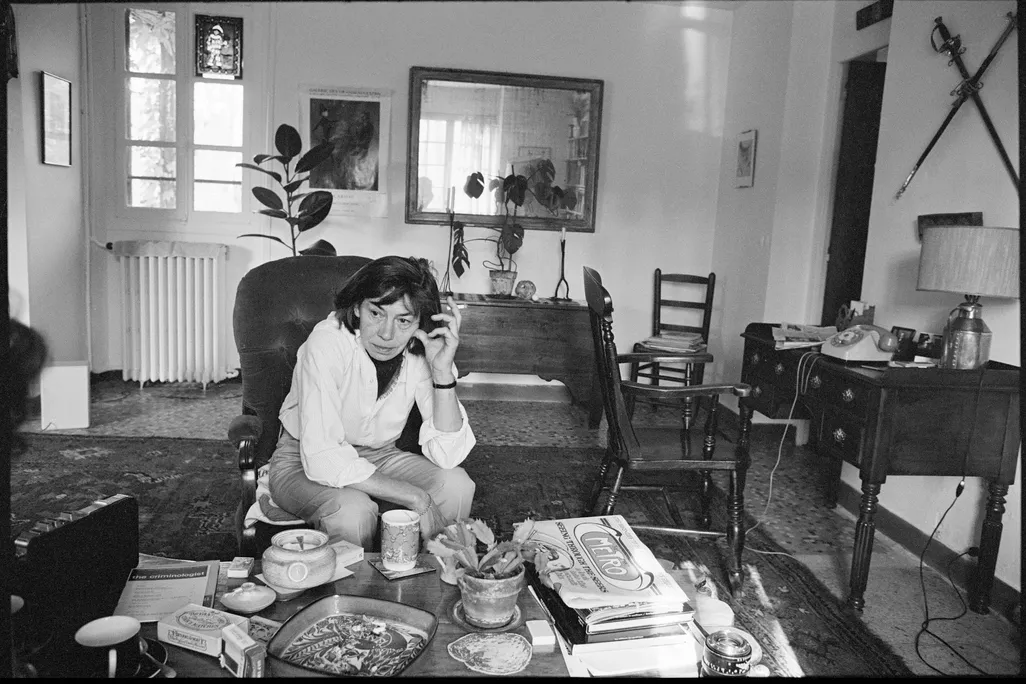 Portrait of American novelist Patricia Highsmith as she sits in the living room of her home in France.