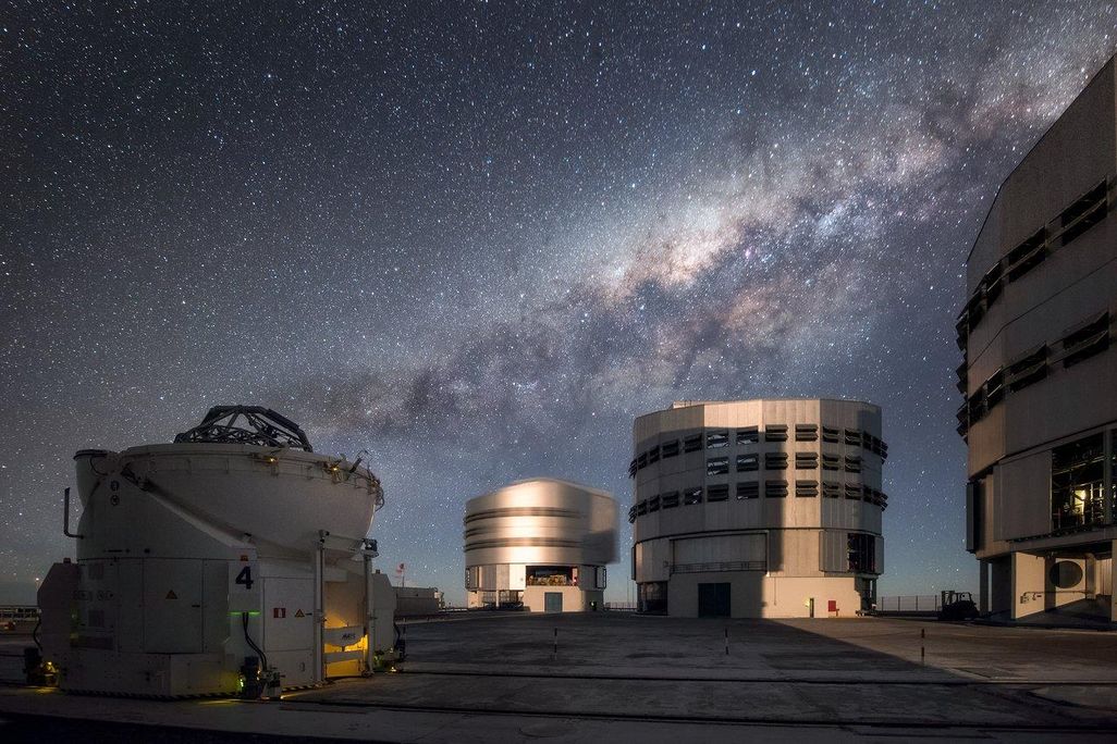Three of the Very Large Telescope's buildings underneath the Milky Way at night