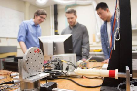 Jason Moore, an associate professor of mechanical engineering at Penn State, David Pepley, a doctoral student studying mechanical engineering, and Yichun (Leo) Tang, an undergraduate student studying mechanical engineering, work with the needle simulator training device.