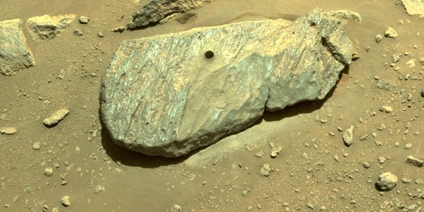 An image of a boulder with a hole drilled into it. The photo was taken by the Mars rover on Planet Mars and shows where the rover obtained its first rock sample from. 