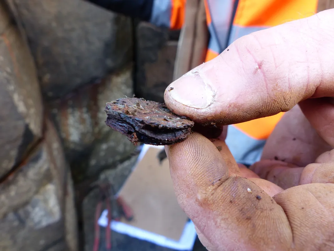 Close-up shot of person's fingers holding rusty coins