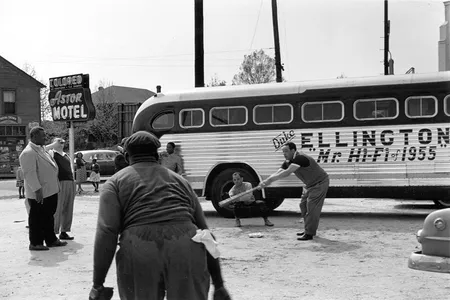 Duke Ellington and band members playing baseball in front of their segregated motel ("Astor Motel") while touring in Florida.