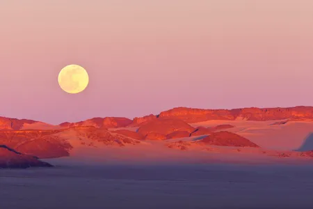 The moon rises over the Sahara Desert. New research links a rising moon to lower humidity and a decreased chance of rain. 