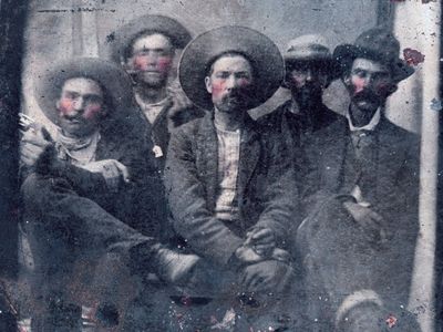 The image depicts the outlaw Billy the Kid, posing alongside the sheriff who later killed him.
