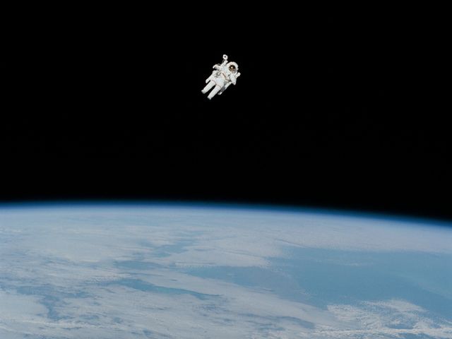 Bruce McCandless floats freely in space with Earth 170 miles beneath him.