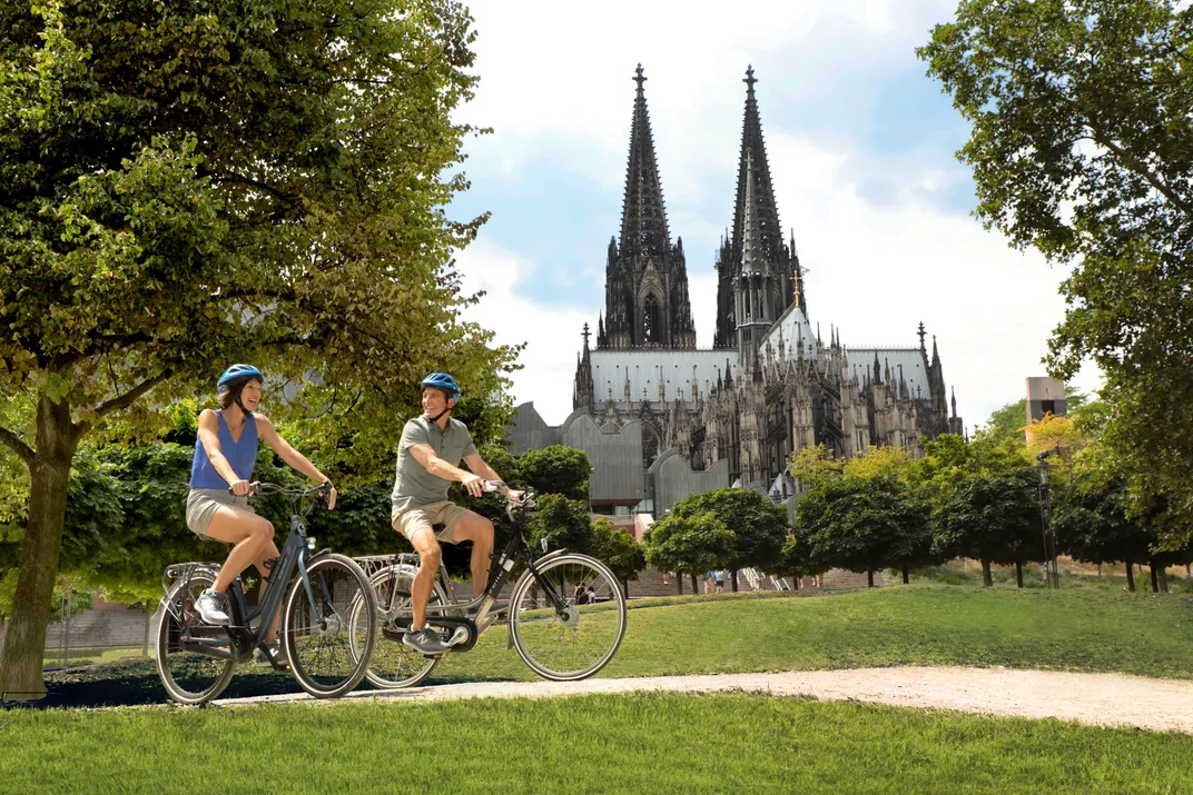 Biking past the cathedral in Cologne. Credit: AMA Waterways