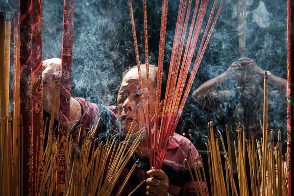 Man lighting incense in Thien Hau Pagoda thumbnail