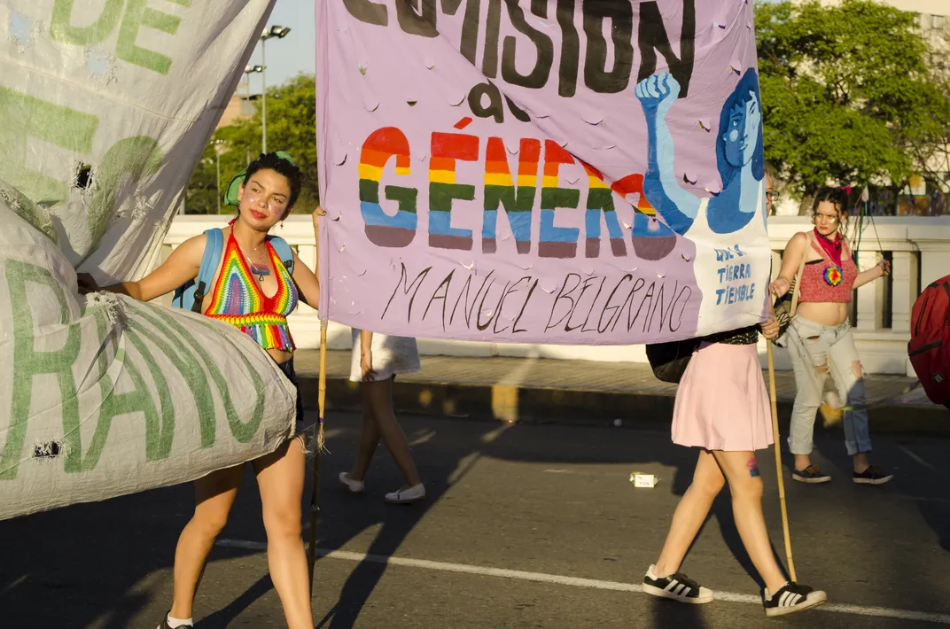 participants hold up signs during a Pride parade