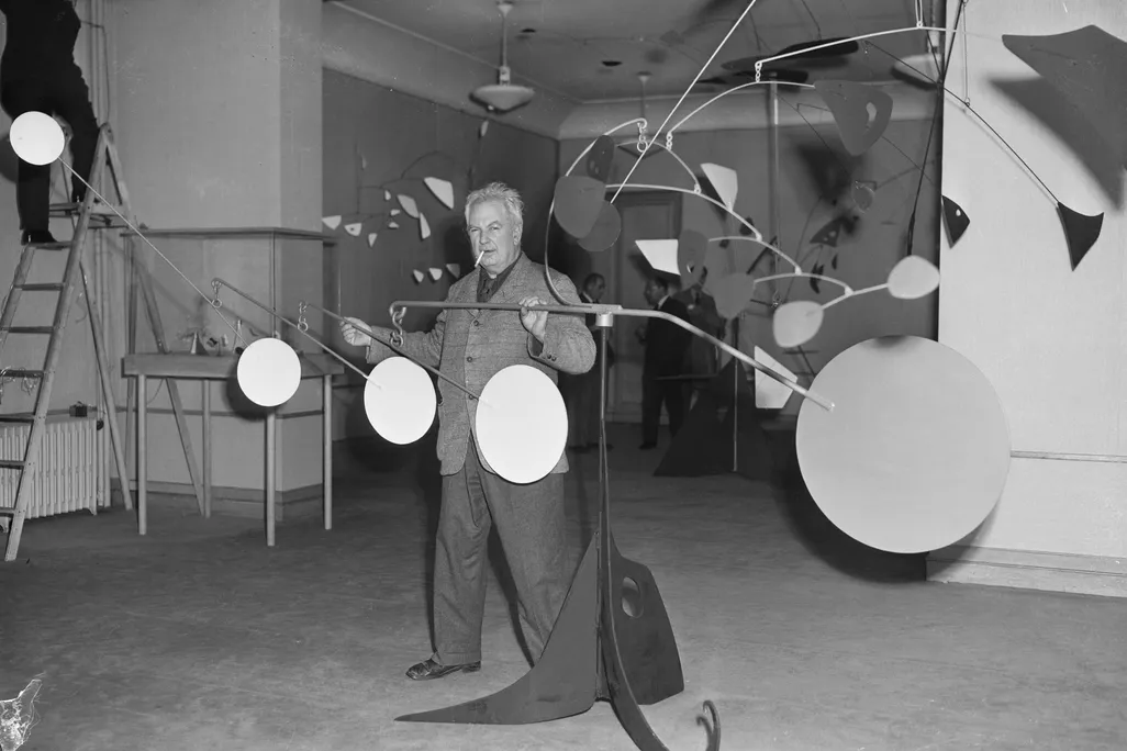 Sculptor Alexander Calder and one of his mobiles