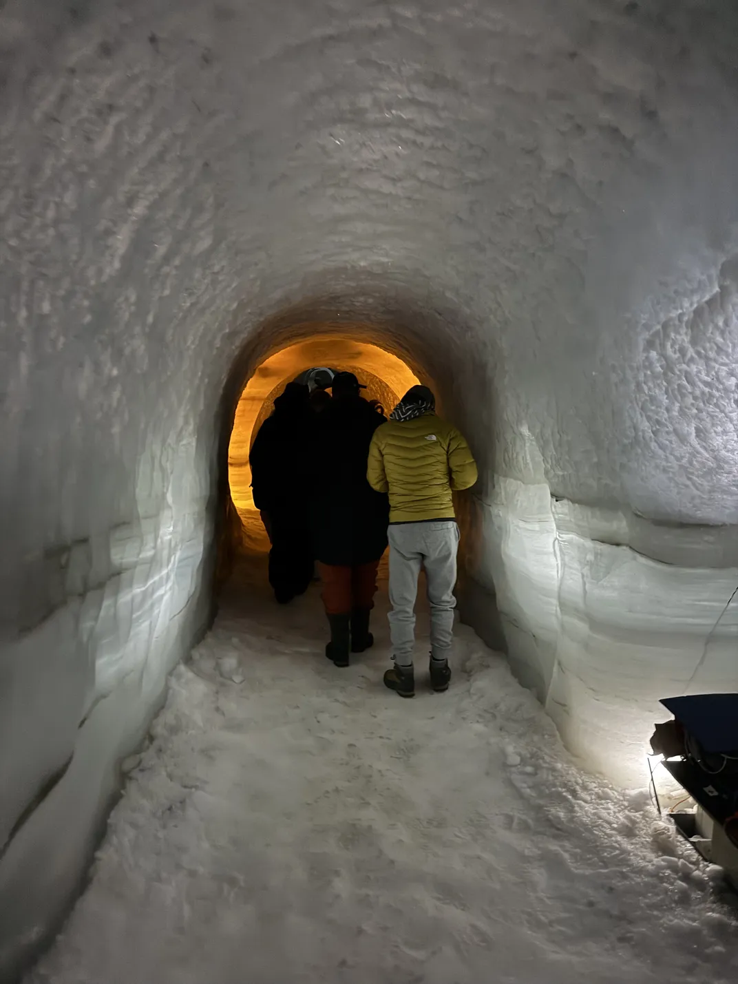 people walk through an ice tunnel
