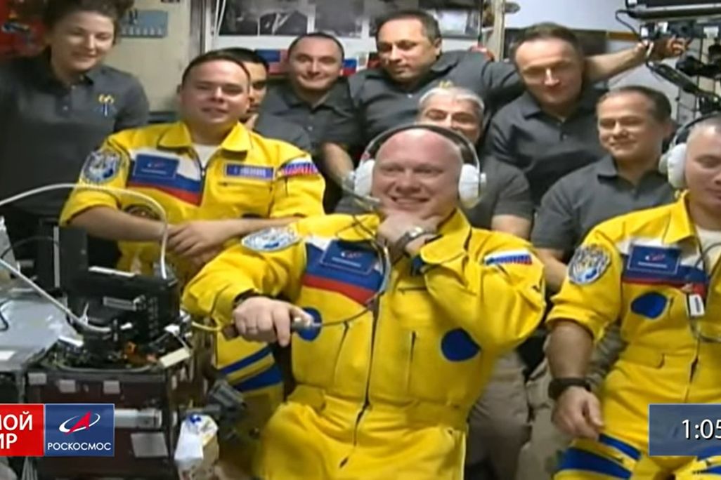 three russian astronauts inside the crowded international space agency after they arrive friday wearing yellow and blue coveralls