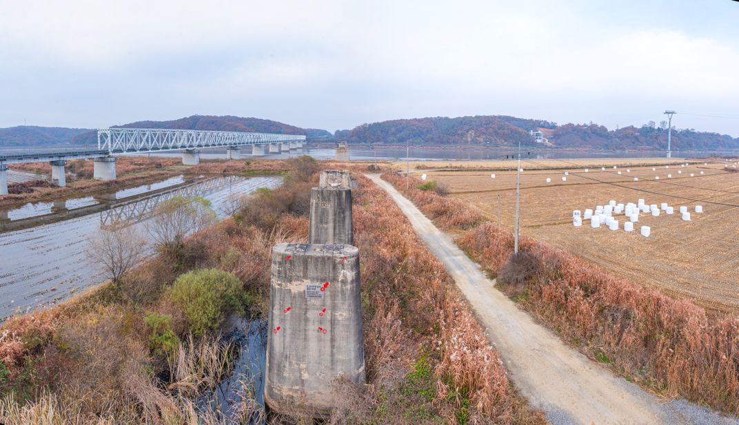 Pilings of a destroyed bridge bearing marks of past conflict in the DMZ