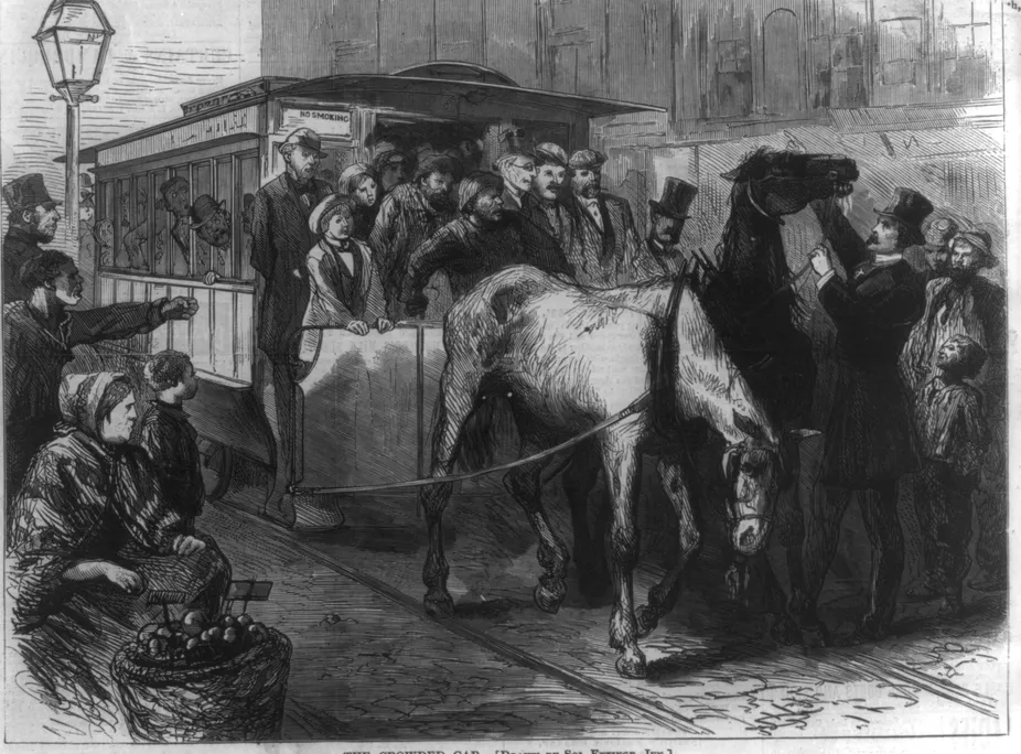 Man in top hat touching horse pulling a streetcar, as a tired horse droops its head