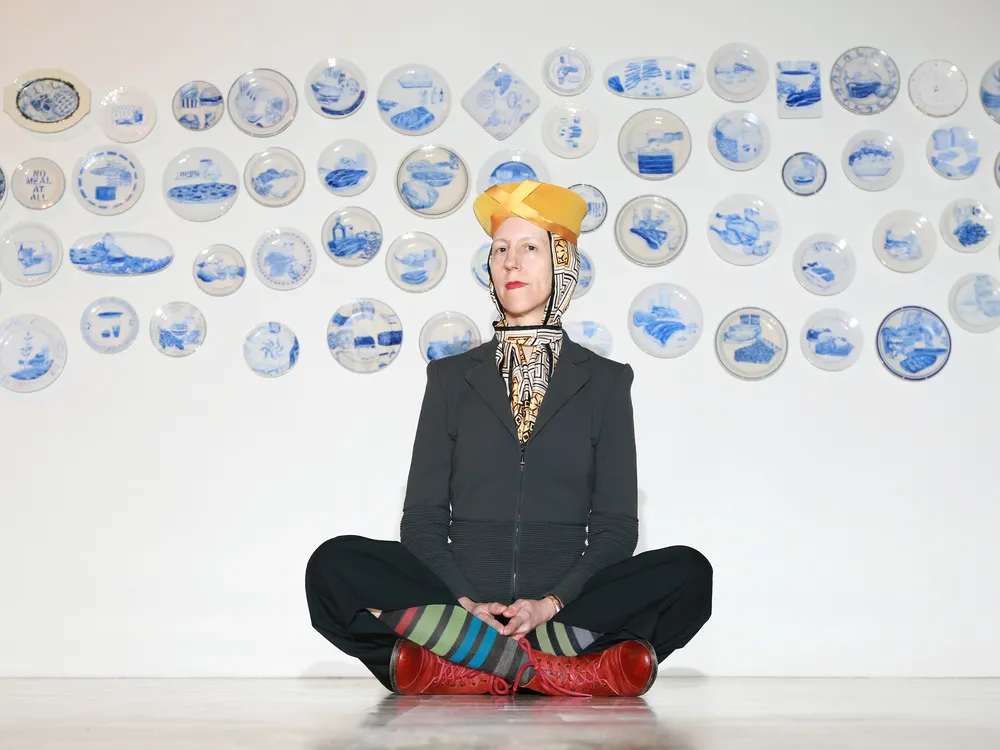 Artist Julie Green poses in front of a selection of The Last Supper ​​​​​​​plates in 2015.