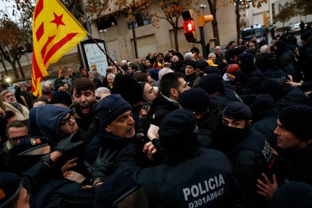 Catalan Mossos d'Esquadra officers scuffle with demonstrators as they cordon off the area around Lleida museum in the west of Catalonia, Spain, on Monday, Dec. 11, 2017.