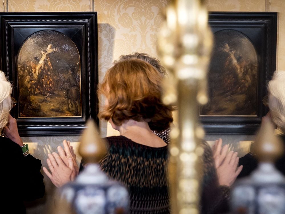 Visitors are reflected in a mirror as they look at The Creation of Jesus on the Cross by Rembrandt on display at Museum Bredius in The Hague on November 3, 2022.