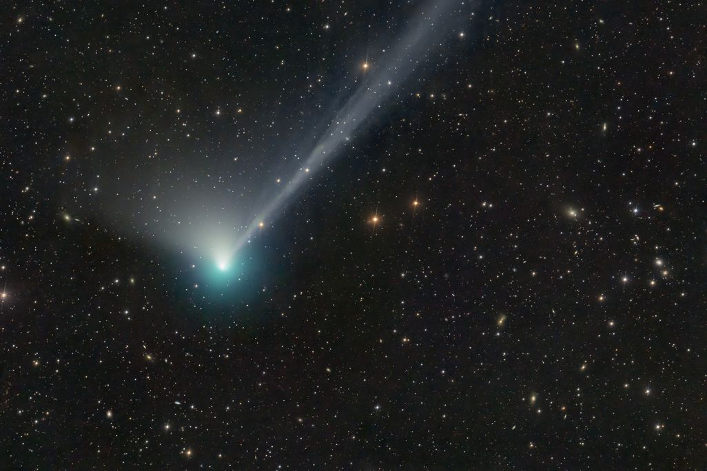 a green-blue comet against stars