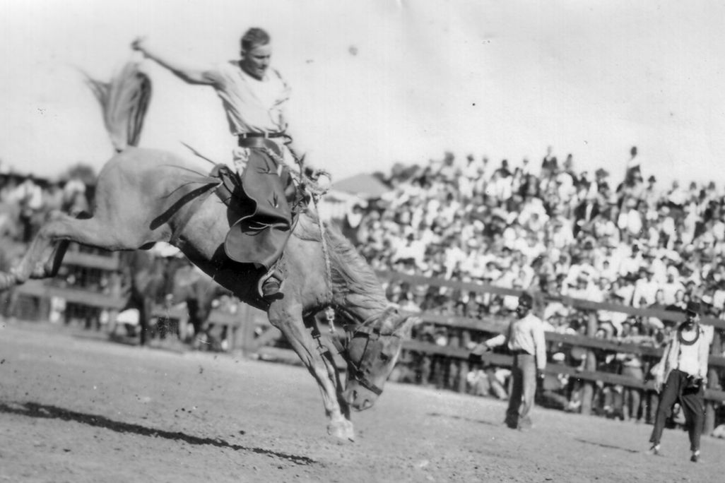 A convict hangs on to a bucking bronco c. 1940