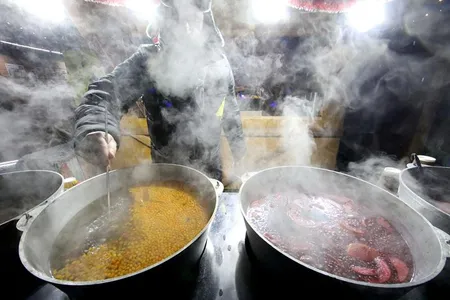 Steam hides a vendor stirring mulled wine with sea buckthorns at a Christmas market in Svobody Square, Kharkiv, northeastern Ukraine.