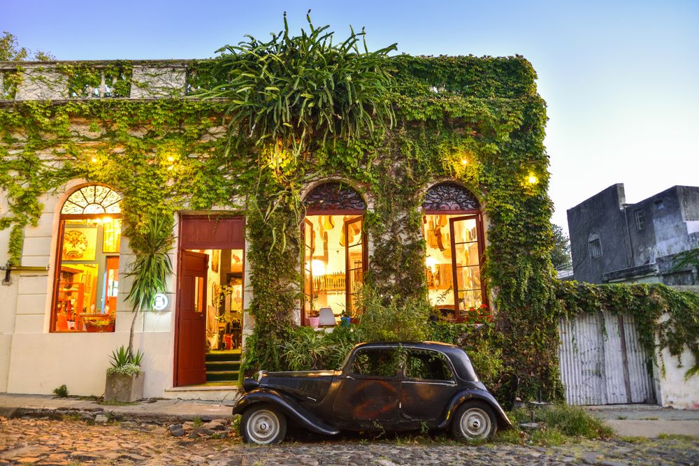 An old timer is parked on a cobble stone street outside a historic building in Colonia del Sacramento, Uruguay. The entire town is like a time bubble where history is alive and well.