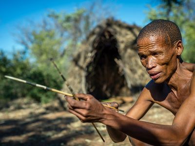 A San man prepares his arrows for hunting in the Living Museum of the Ju’Hoansi-San, Grashoek, Namibia