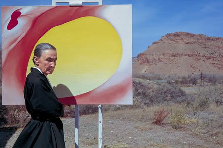 American artist Georgia O'Keeffe poses outdoors beside an easel with a canvas from her series, 'Pelvis Series Red With Yellow,' Albuquerque, New Mexico, 1960. 