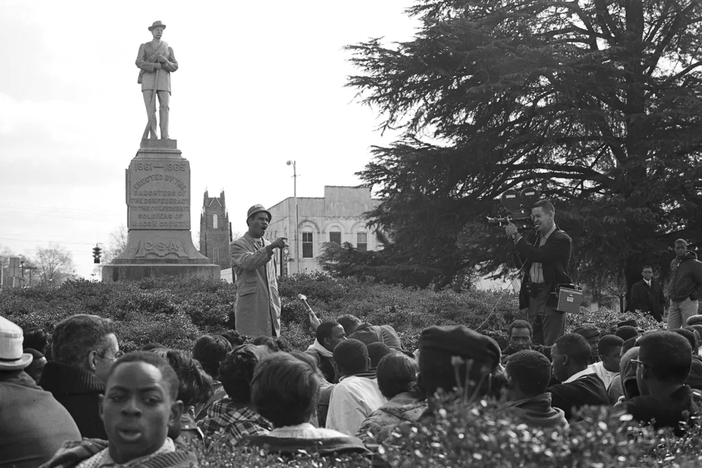 Tuskegee history professor Frank Toland speaks to the gathered students at the base of the Confederate monument