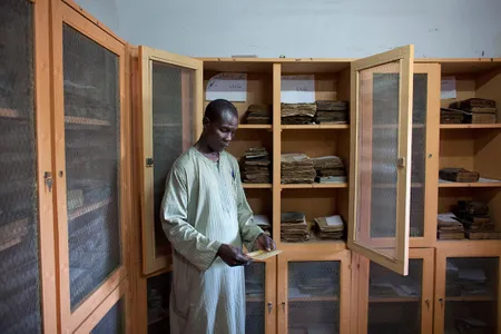 Librarian Aboubakar Yaro examines an Islamic manuscript from the 17th century at the Djenne Library of Manuscipts, in Djenne, Mali, September 2012. Djenne is thought to have at least 10,000 manuscripts held in private collections, dating from the 14th to 20th centuries.