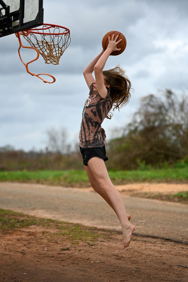 A girl in rural northwest Florida dunks in bare feet thumbnail