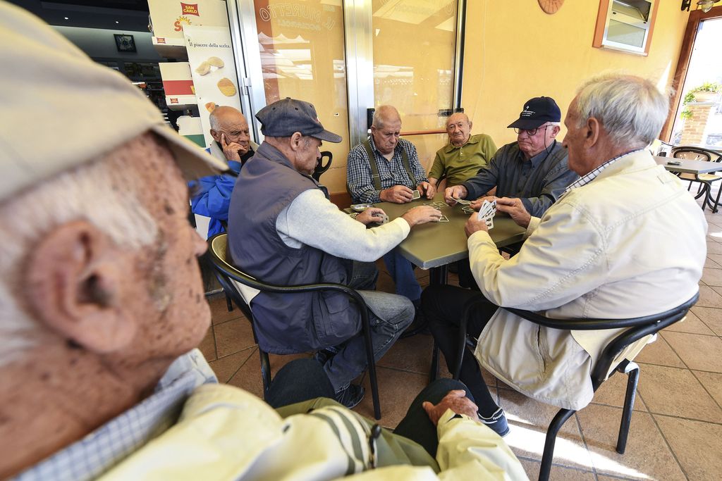 A group of old men playing cards in a bar