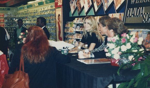 Claudia Schiffer sitting at a table