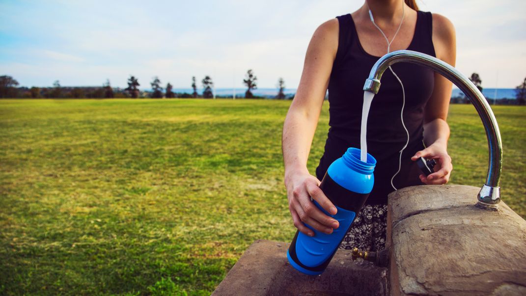 Image of jogger refilling a reusable water bottle.